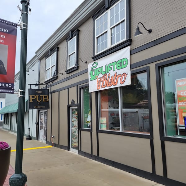 Exterior view of Uplifted Bistro, a cafe, with its sign and storefront windows.
