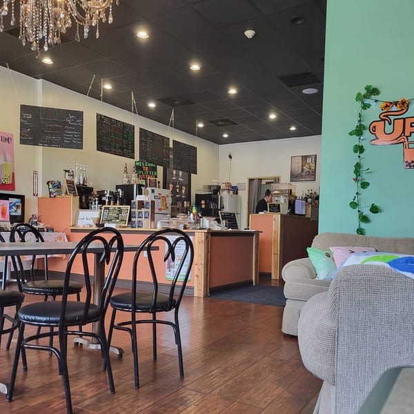 Interior of Uplifted Bistro cafe with tables, chairs, a counter, and a cozy seating area.