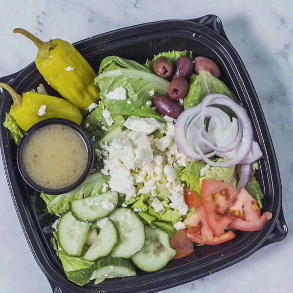 Uplifted Bistro's Greek salad with lettuce, feta, olives, tomatoes, cucumbers, onions, and dressing.