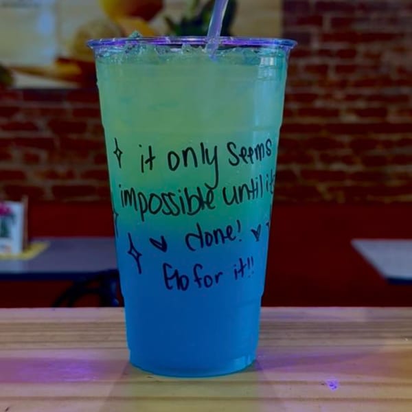 Uplifted Bistro's blue and green layered drink with an inspirational quote on the cup.