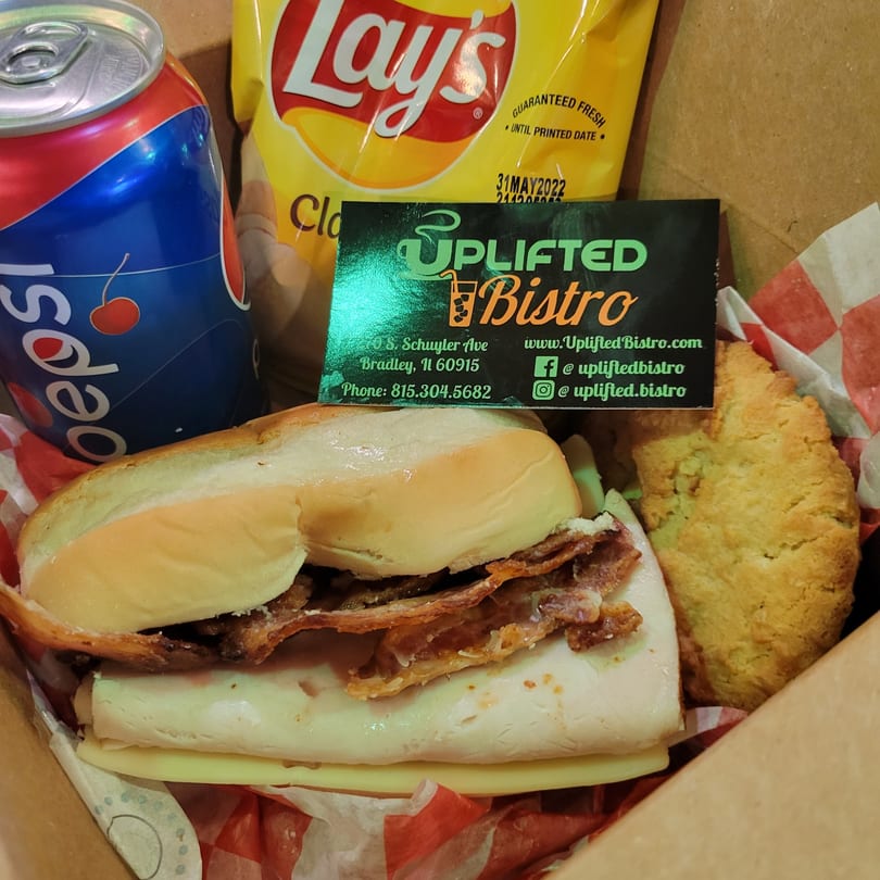 Uplifted Bistro sandwich with bacon, cheese, and turkey, alongside a Pepsi, chips, and a cookie.